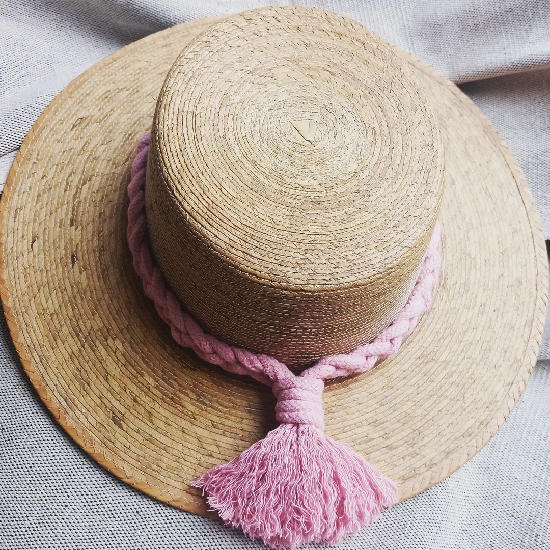 Sombrero de palma, ala plana. Macramé con cordón de algodón rosa claro.